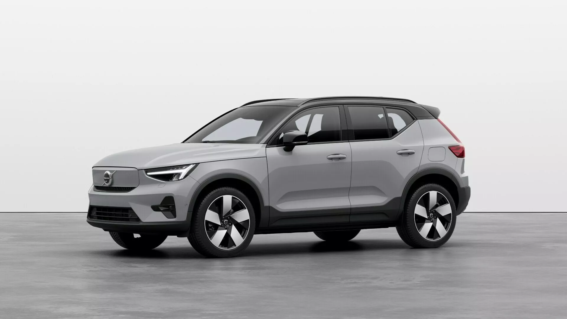 2024 Volvo EX40 1:a generationens elektriska SUV i studioinställning, visar främre och sidoprofiler med LED-strålkastare, stängd grill, flerspakiga legeringshjul och högteknologiska sensorer