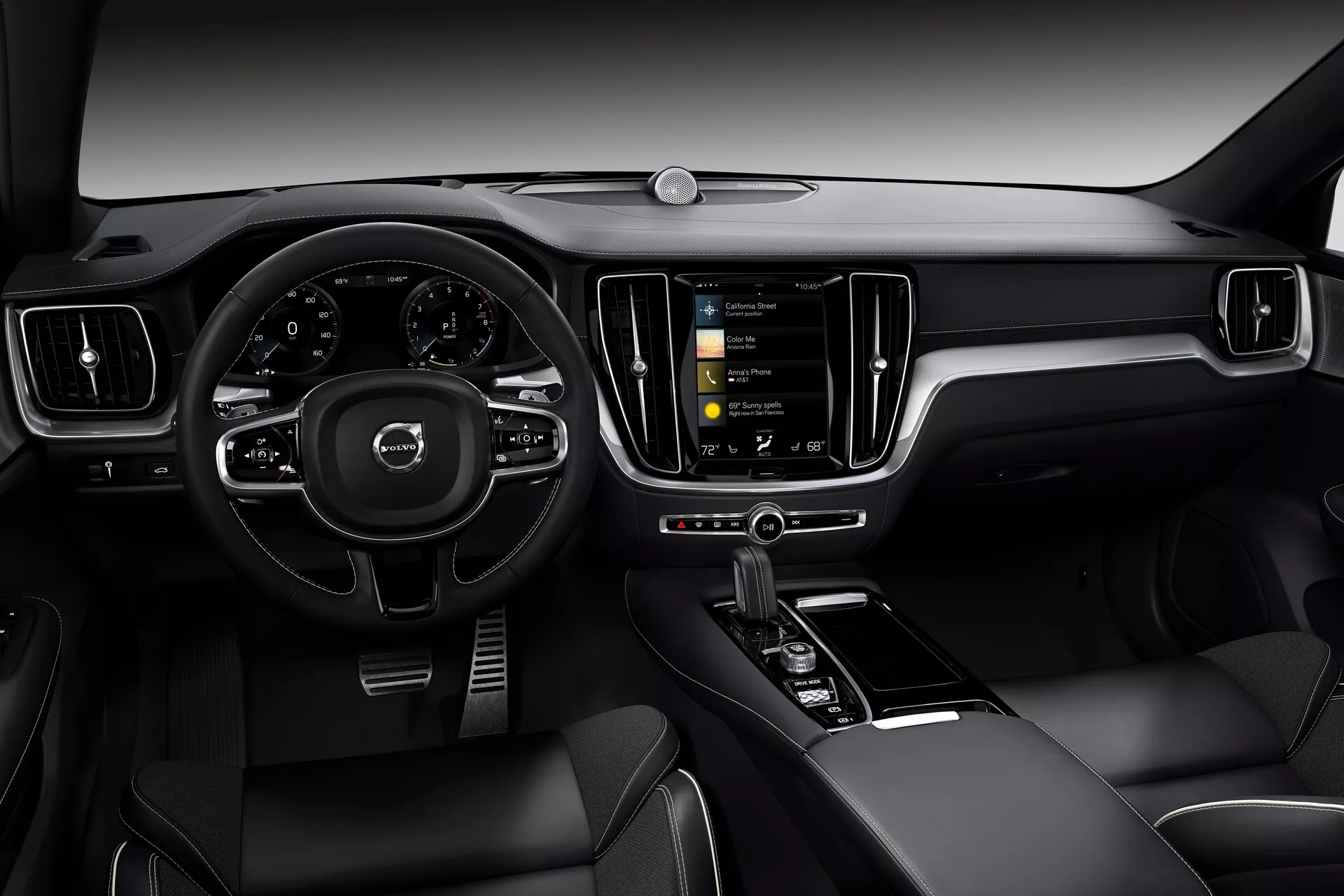 Interiörvy av 2018 Volvo S60/V60 (3:e generationen) från förarens perspektiv. Bilden fokuserar på en modern, tekniskt avancerad instrumentpanel med en treekrad multifunktionell ratt, en delvis synlig digital instrumentpanel och ett vertikalt orienterat pekskärms-infotainmentsystem. Interiören är tillverkad av läder eller läderliknande material med metallaccents och inkluderar ett panoramatak, vilket återspeglar en lyxig och innovativ bilinteriördesign.