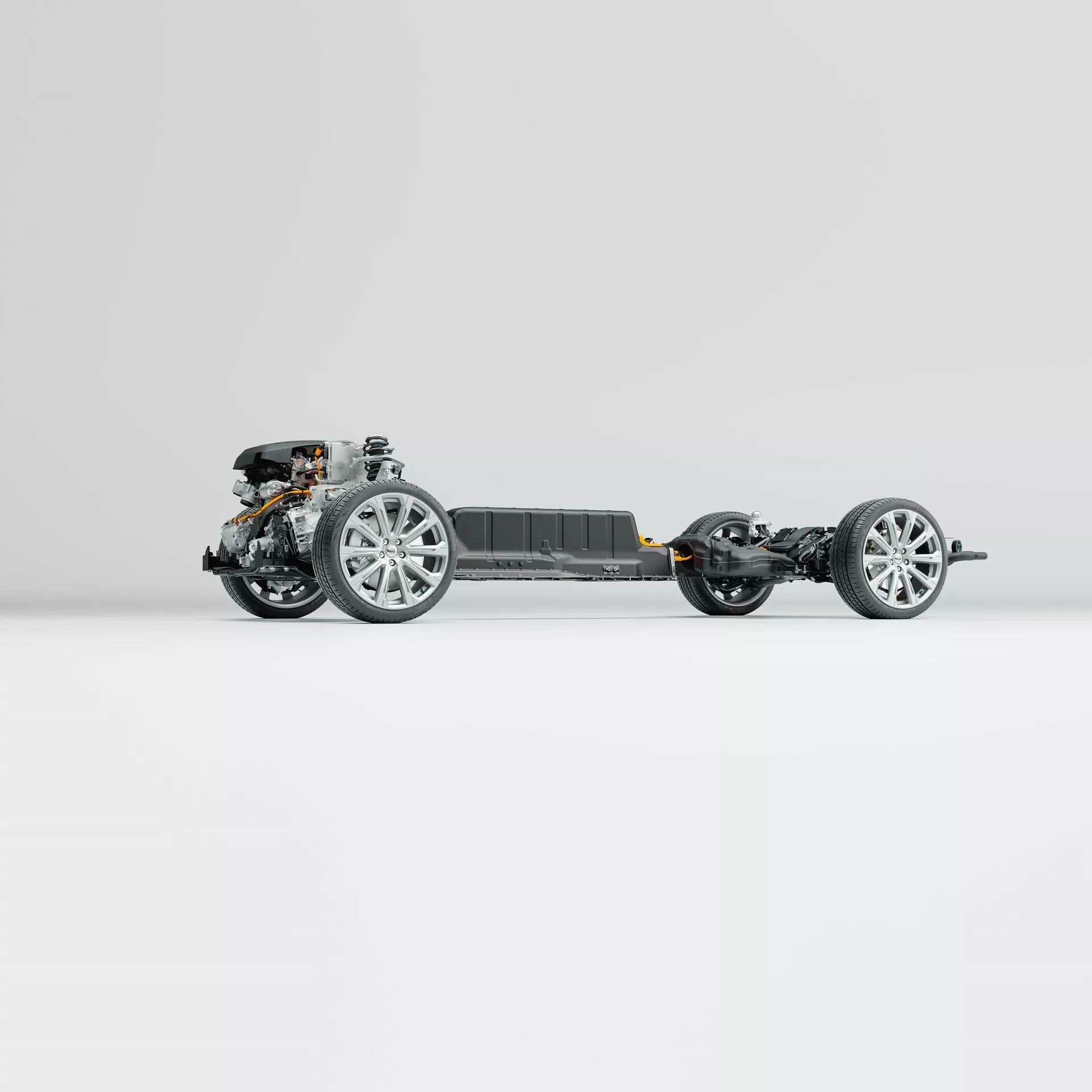 Sidoprofil av chassit på en Volvo XC60 2021 (andra generationen-facelift). Bilden framhäver fordonets ram, hjul utrustade med moderna legeringsfälgar, fjädringskomponenter, framdrivningssystemet och ett centralt batteripaket, allt på en ren och neutral bakgrund. Fotot avslöjar avancerad ingenjörskonst utan kaross eller interiörkomponenter.