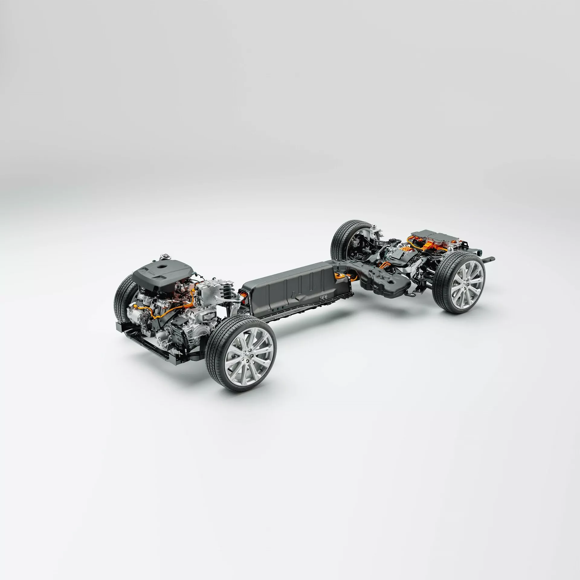 Trekvart toppvinklad vy av Volvo XC60 2021 (andra generationens facelift) plattform utan kaross-paneler, som visar chassi, drivlina och fjädringskomponenter. Fordonet centrerat mot en neutral ljusgrå bakgrund. Framsidan av bilen är i botten, något svängd åt vänster, vilket ger en klar bild av framhjulen och fjädringen. Detaljerad vy av styrmekanism, hjulsammansättning med sportiga aluminiumfälgar och bromskomponenter. Mittsektionen synliggör batteripaketet som indikerar en elbilsplattform (EV), integrerad i golvet för lägre tyngdpunkt. Elmotor och drivlina syns bakom batteripaketet, vilket tyder på bakhjulsdrift eller fyrhjulsdrift. Bakhjulen har en liknande fjädringsinstallation och bromskomponenter. Idealisk för kategorier som fordonsteknologi, elbilar, maskinteknik och fordonsdesign.