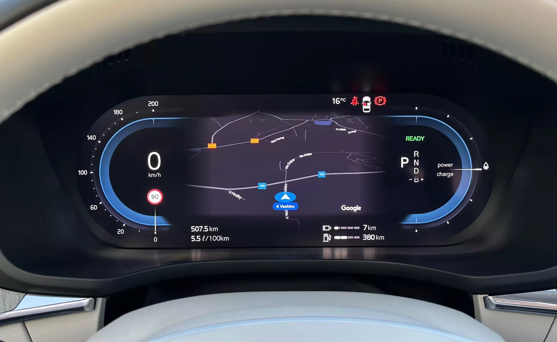 Vy av den digitala instrumentpanelen i Volvo XC60 Recharge Plug-In Hybrid 2021 från förarens perspektiv, med hastighetsmätare, bränsleeffektivitetsmätare, energianvändning, navigeringskarta och olika körindikatorer