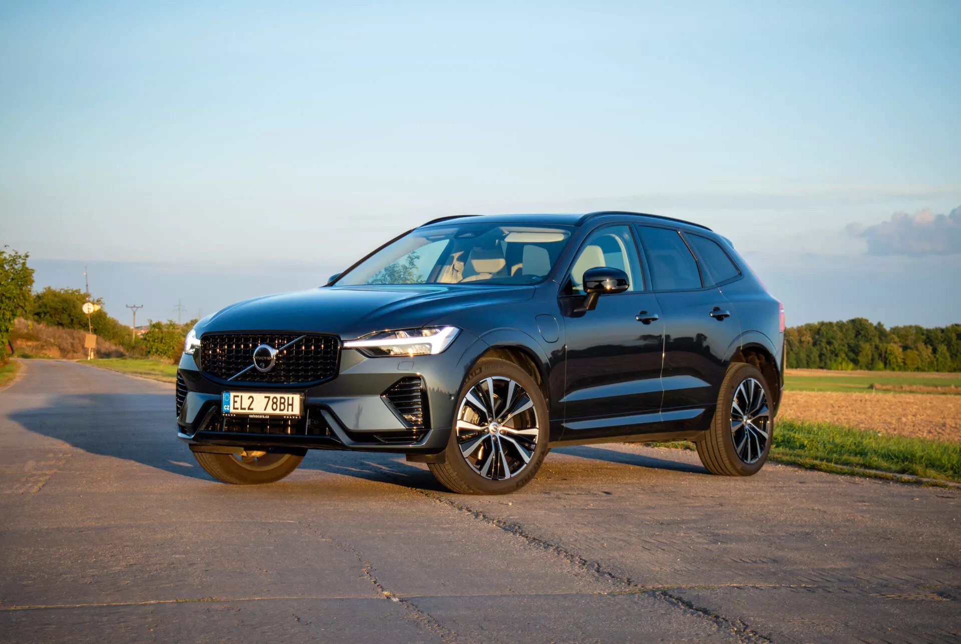 Mellanstort SUV Volvo XC60 Recharge Plug-In Hybrid 2021 i en slank och sportig design, med LED-strålkastare Thor's Hammer, avancerade legeringshjul och en skulpterad frontgrill, fångad i varmt sen eftermiddagsljus från en framifrån tredje kvarts vinkel som visar den dynamiska sidoprofilen och fronten.