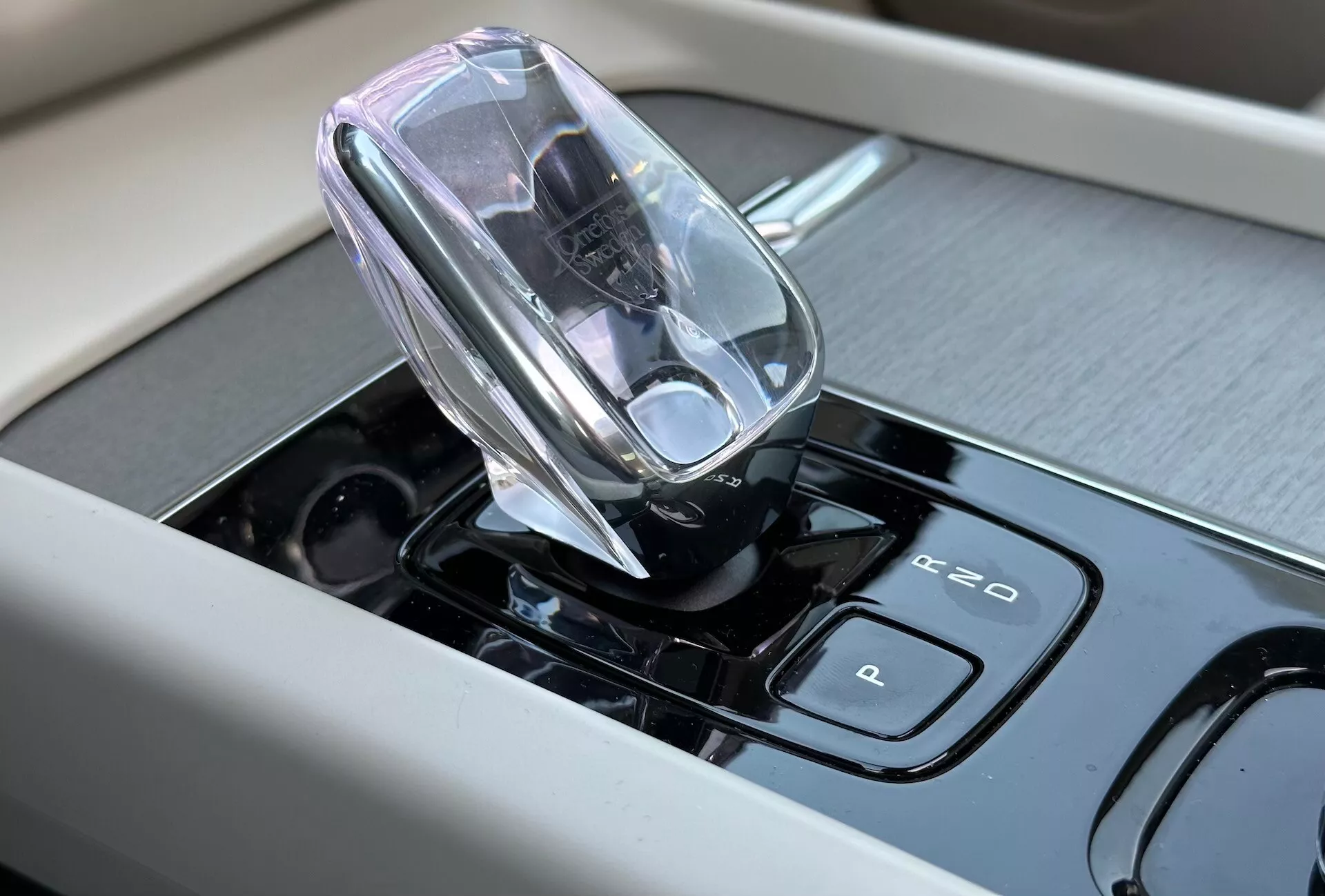 Närbild av interiören i Volvo XC60 Recharge Plug-in Hybrid 2021 med fokus på den högteknologiska elektroniska växelspaken och pekkänsliga kontroller