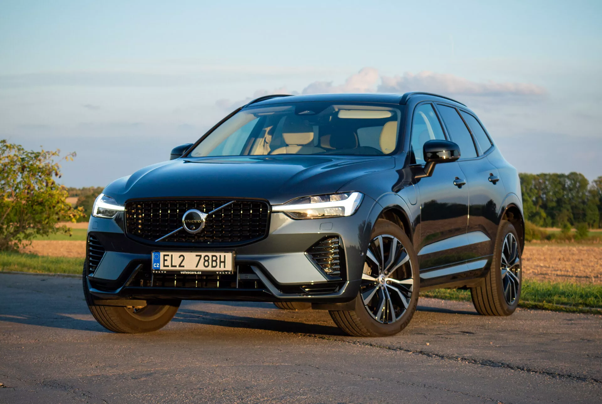 2021 Volvo XC60 Recharge Plug-In Hybrid SUV parkerad på asfalt, visar sin eleganta design och avancerade tekniska funktioner från en låg främre trekvarts vinkel