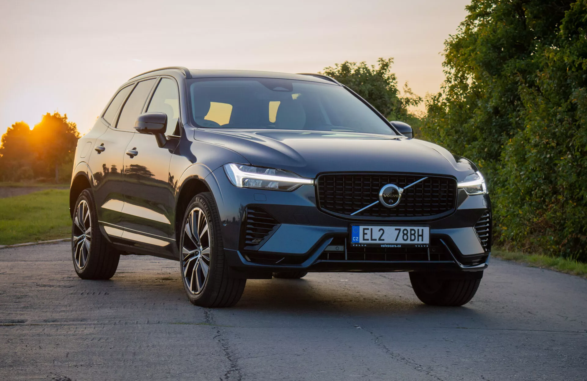 Volvo XC60 Recharge Plug-In Hybrid 2021 i en modern SUV-design placerad i en lätt vinkel för att framhäva frontens fjärdedel, visar den distinkta grillen, de slanka LED-strålkastarna och den aerodynamiska frontstötfångaren med integrerade luftintag, kompletterad med en glansig yttre finish och premium flerspakiga lättmetallhjul under naturligt dagsljus.