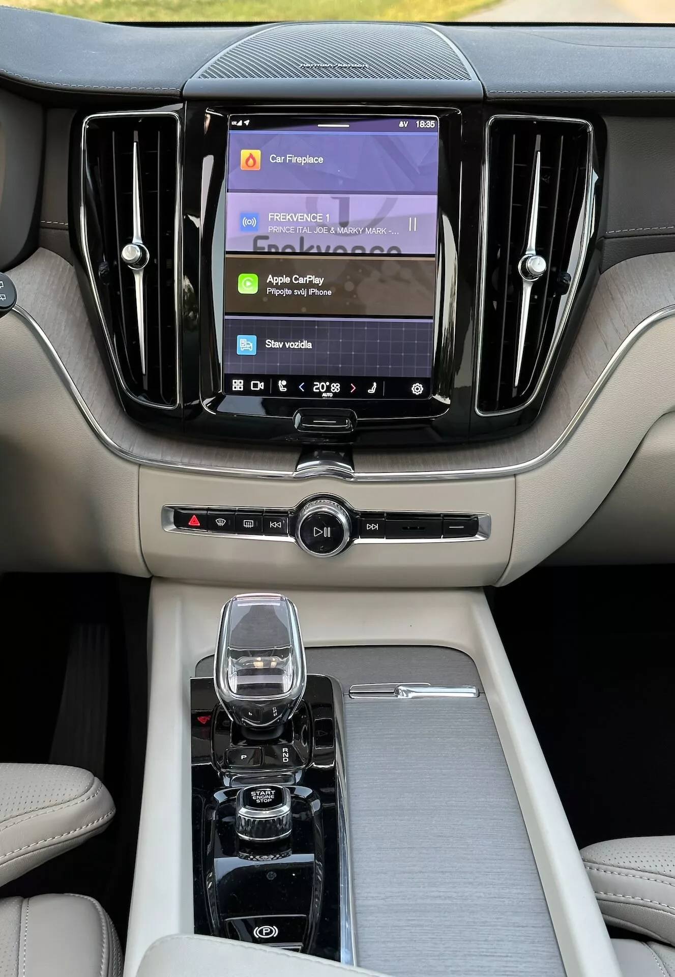 Interiör av Volvo XC60 Recharge Plug-in Hybrid 2021 med fokus på lyxig mittkonsol och instrumentbräda med toppmodernt infotainmentsystem och högkvalitativa material från baksätets perspektiv