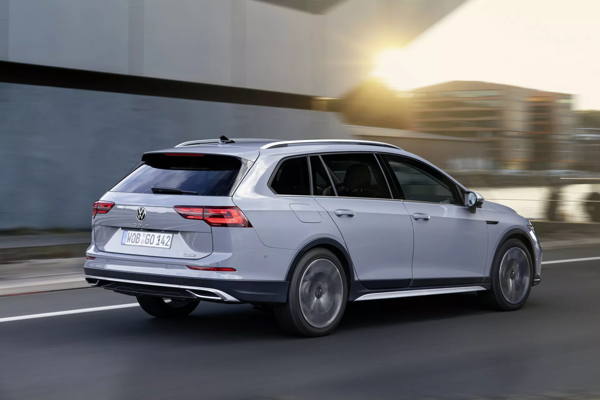 2017 Volkswagen Golf Alltrack stationvagn i rörelse, fångad från ett bakre trekvarts perspektiv som framhäver dess snygga design, LED-bakljus och dubbla avgasrör, i en dynamisk bild som betonar hastighet och modern fordons teknologi
