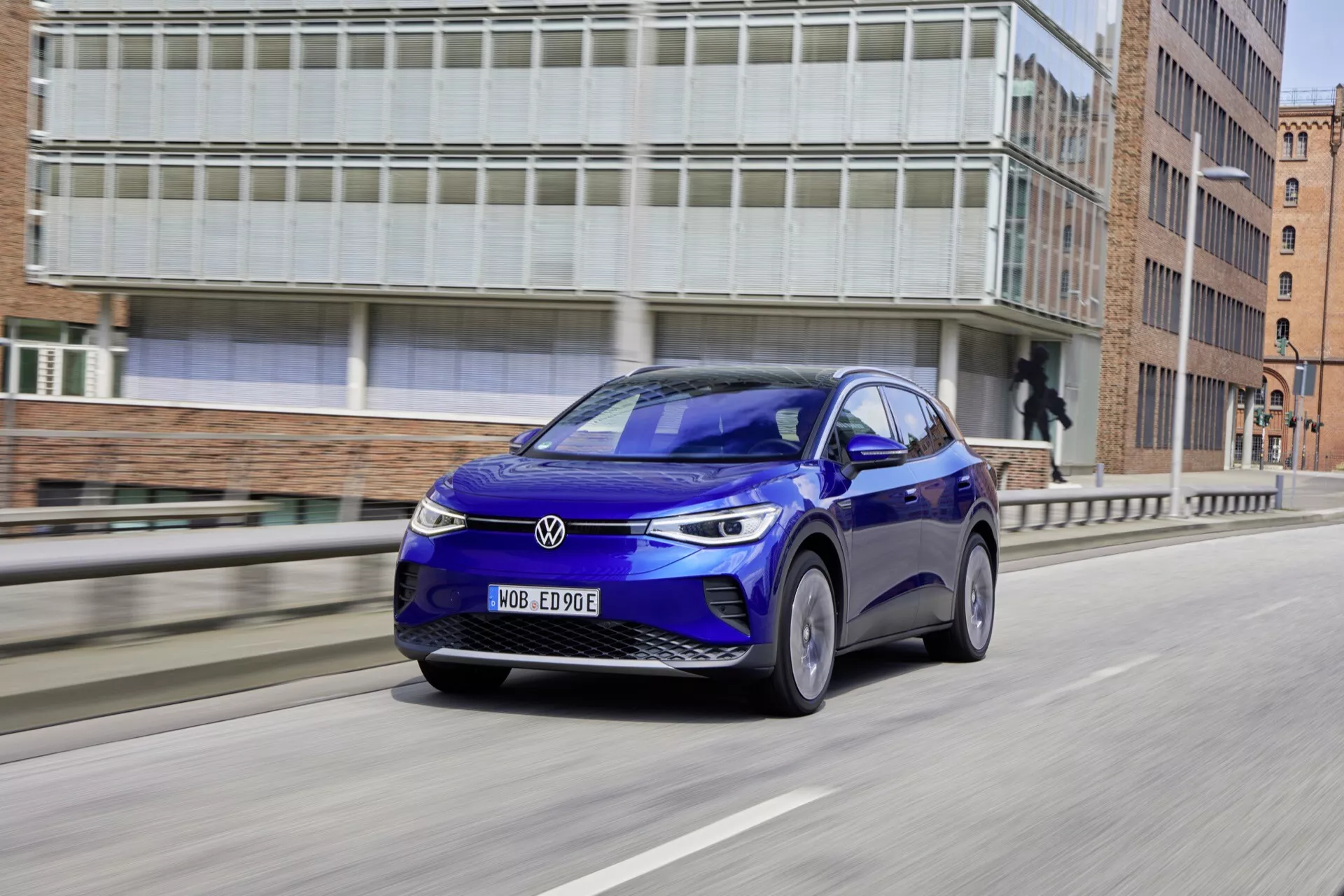 2020 VW ID.4 första generationen i blått, visar aerodynamisk design och moderna teknikfunktioner, kör på en stadsväg