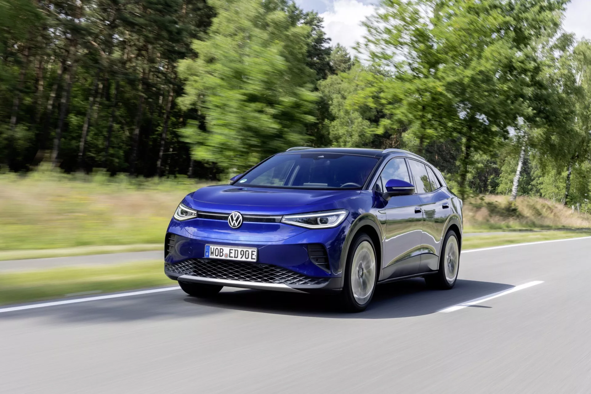 Dynamisk vinkelvy av rörlig Volkswagen ID.4, lyfter fram dess elektriska SUV-design, slanka aerodynamik och moderna LED-strålkastare