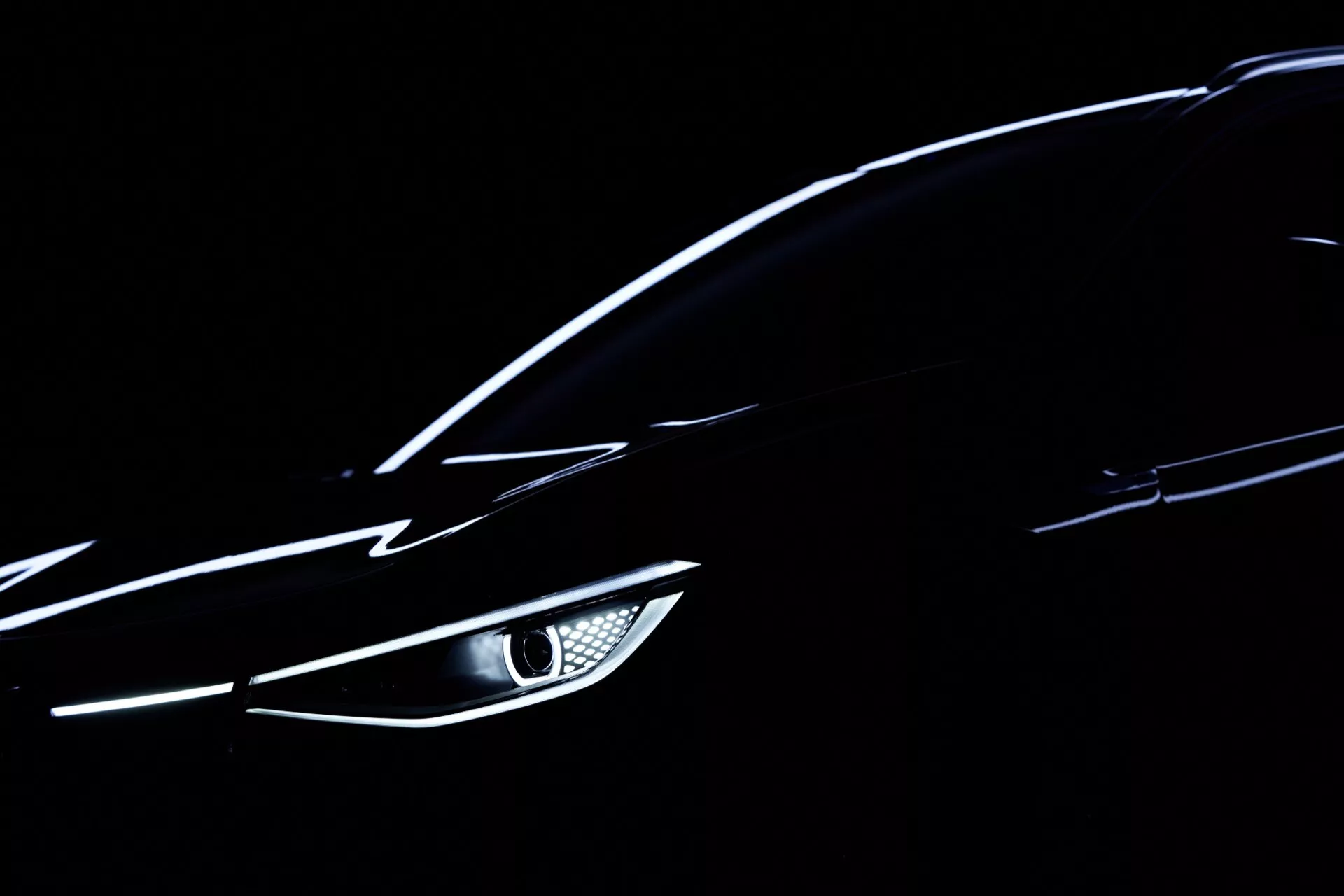 Närbild av en 2020 VW ID.4 (1:a generationen) som framhäver dess vinklade LED-strålkastare, släta aerodynamiska kaross och diskret reflekterande metallisk färg mot en mörk bakgrund - fokuserande på moderna detaljer i fordonsdesign och teknologi.