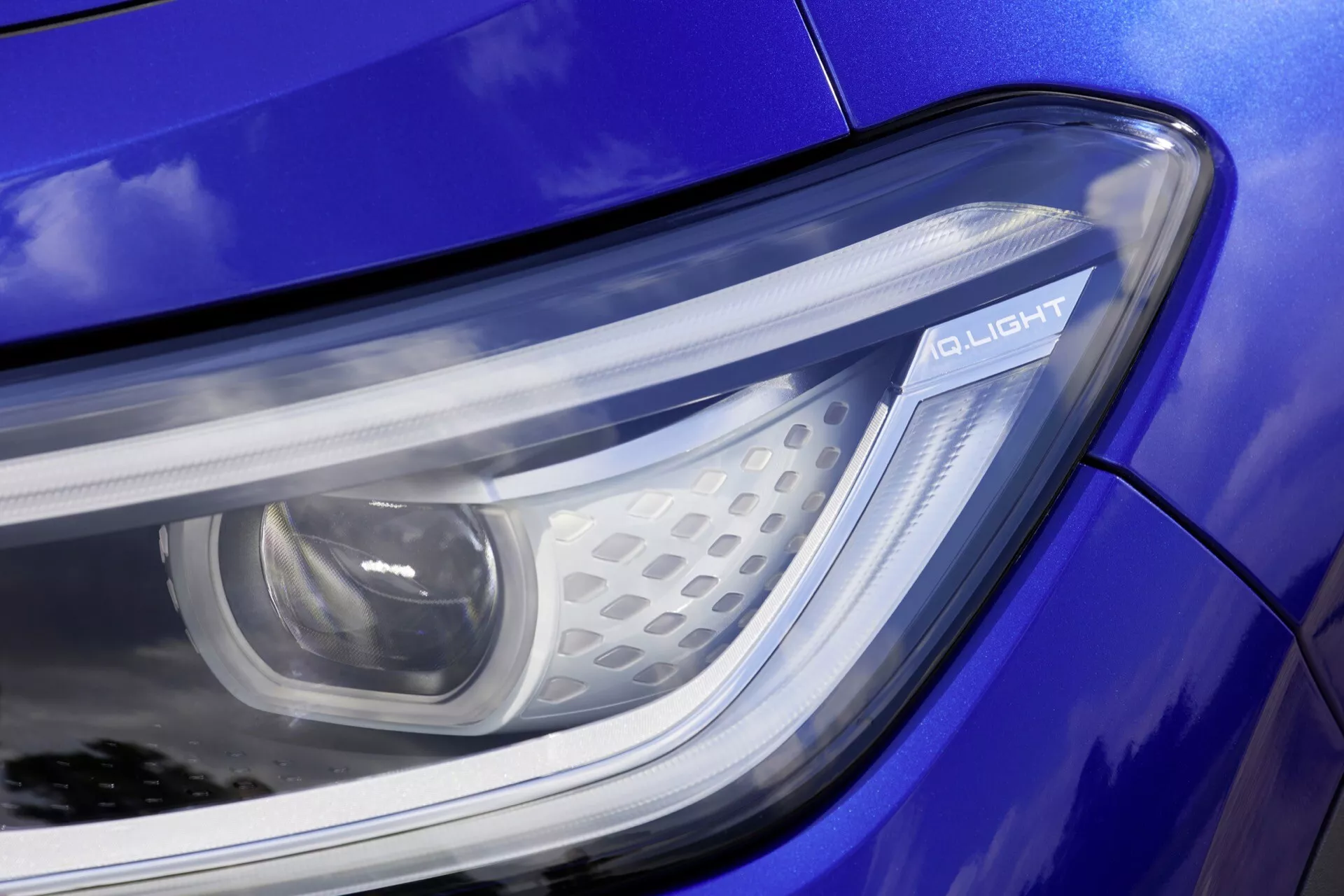 Närbild av strålkastaren på VW ID.4 2020 första generationen som visar LED-teknik och Q LIGHT-inskriften på en blå kaross