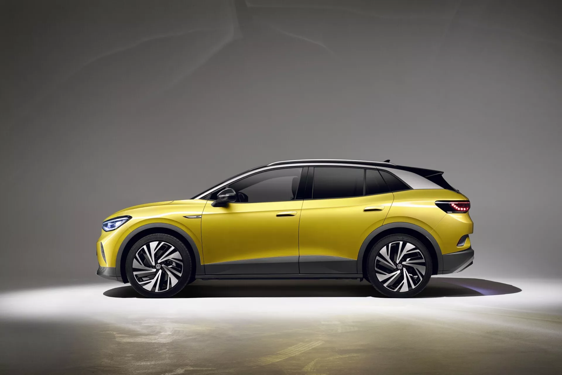 VW ID.4 första generationen 2020 i vibrerande gult med slank profil, avancerade LED-strålkastare, dynamiska legeringshjul och potentiell förarassistans teknologi, mot en neutral bakgrund som framhäver dess crossover/SUV-design och moderna estetik.