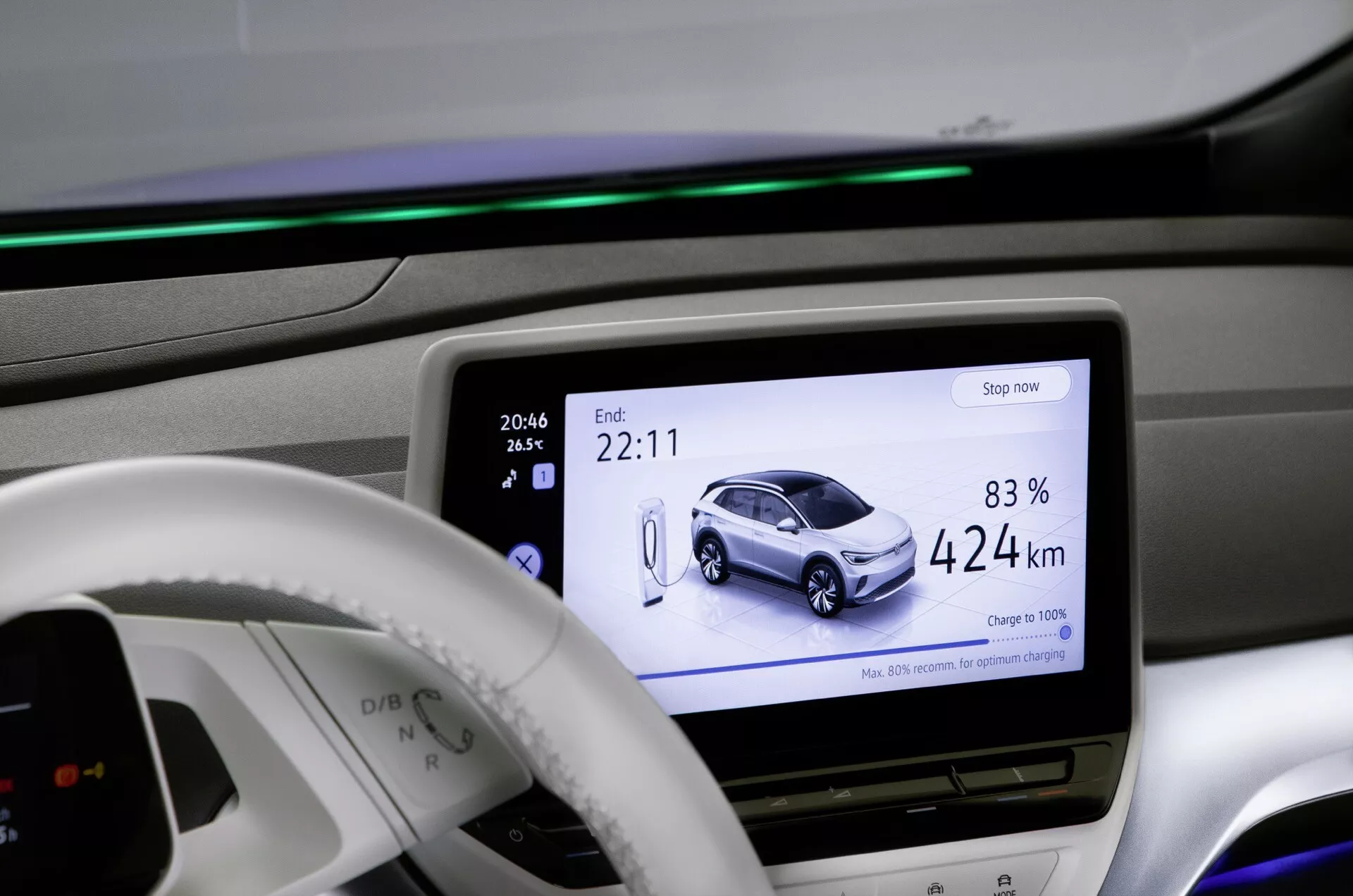 Interiörvy av VW ID.4 2020 som visar den centrala displayen med en grafisk representation av bilen laddad till 83% och med en räckvidd på 424 km, ambient belysning i instrumentbrädan och modern minimalistisk design